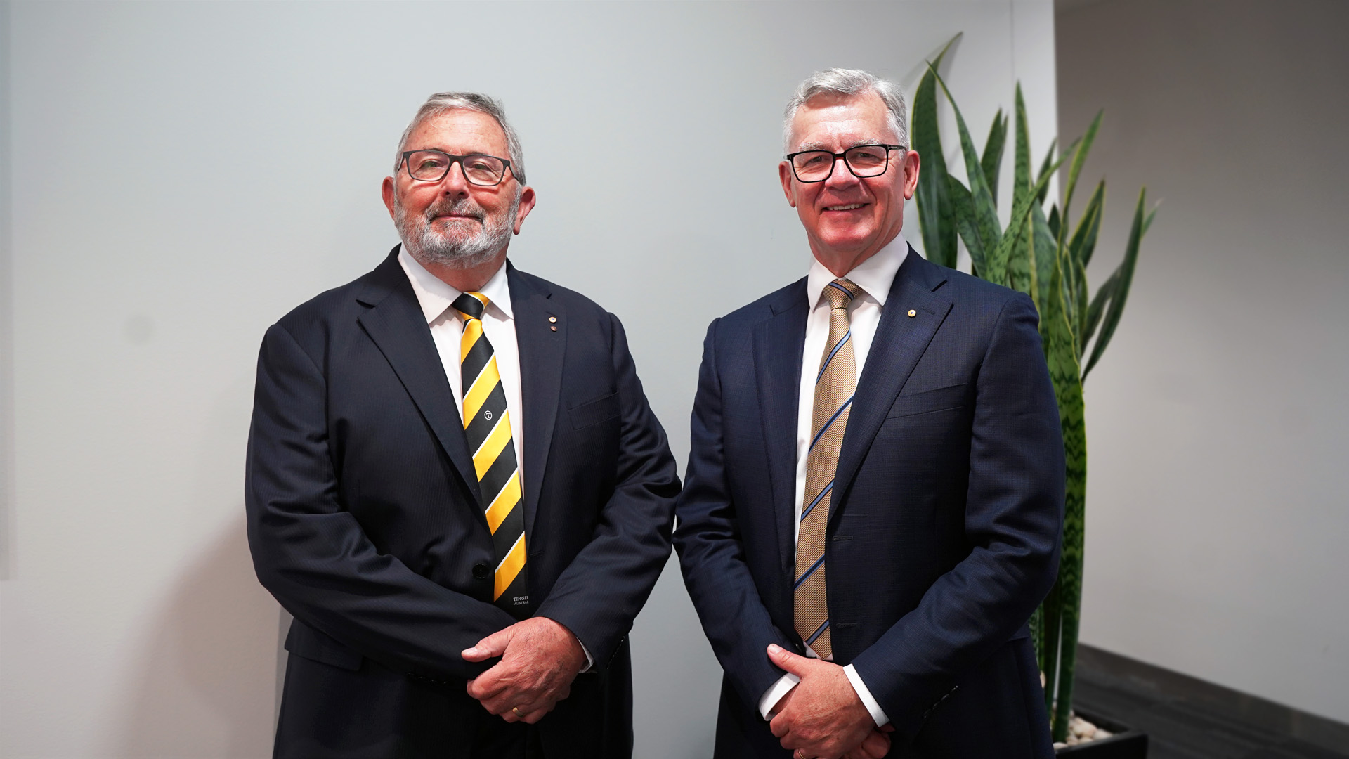 Photo of two men in suits standing